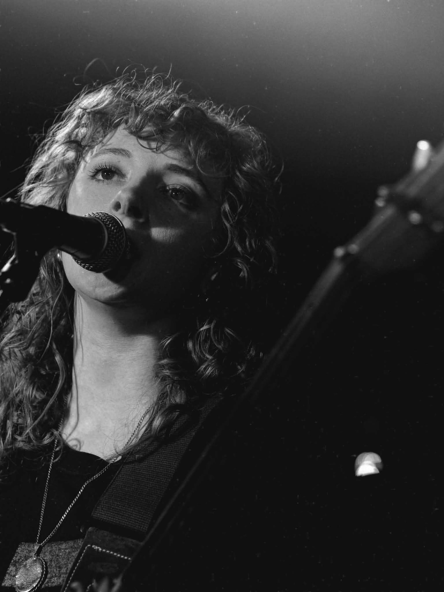 Black and white shot of a bassist singing into the mic at The Water Rats, London