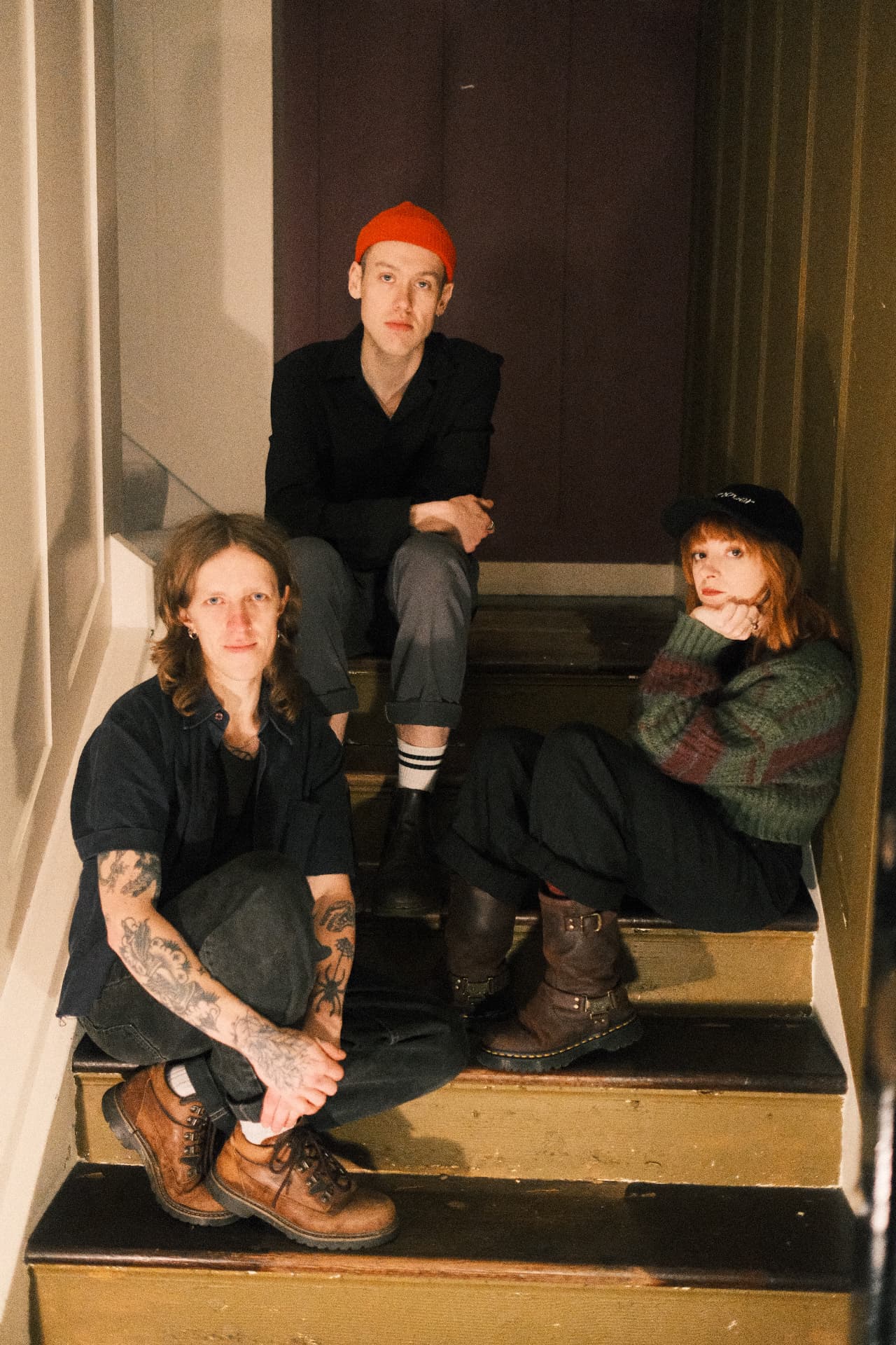 Gaffa Tape Sandy, three band members sitting together on a stairwell