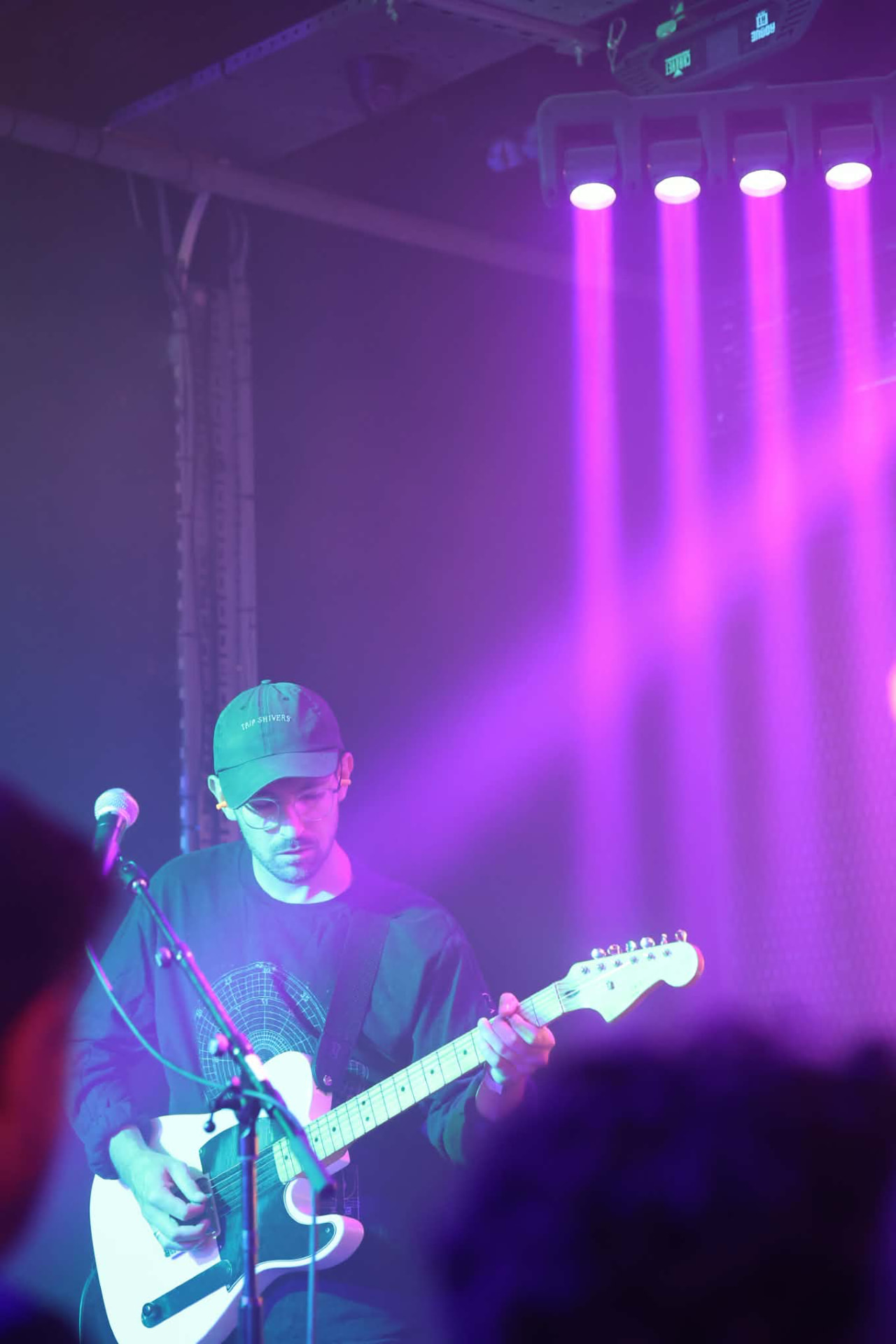 Guitarist in a cap under purple stage light at The Water Rats, London