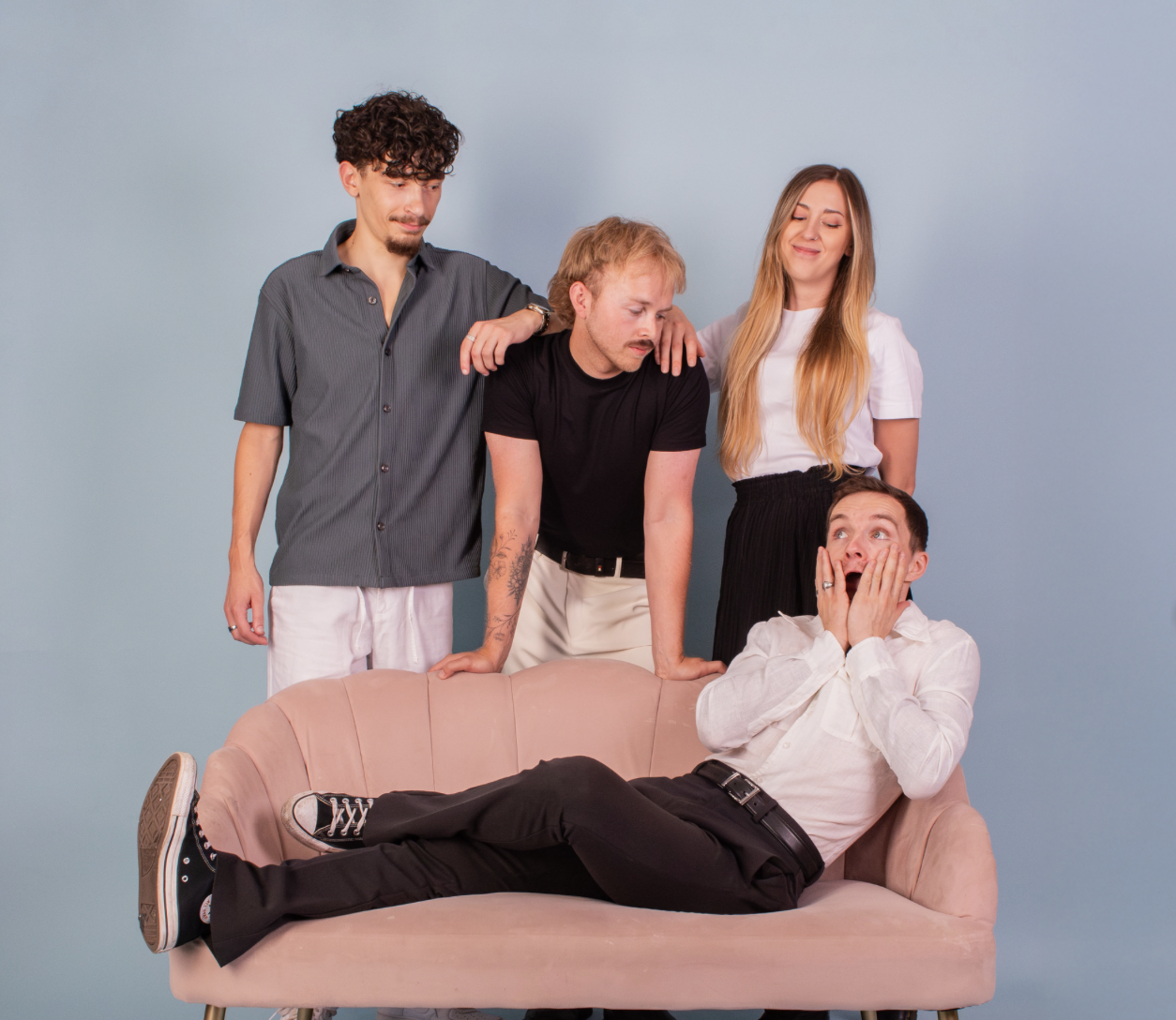 The Last Pioneers, four band members gathered around a pink sofa against a pale blue backdrop
