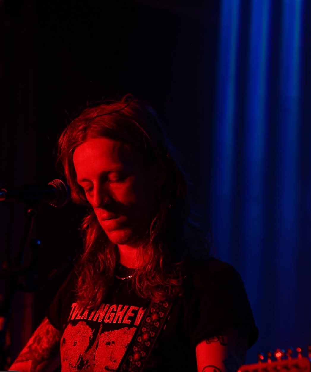 Guitarist bathed in deep red stage light at The Water Rats, London