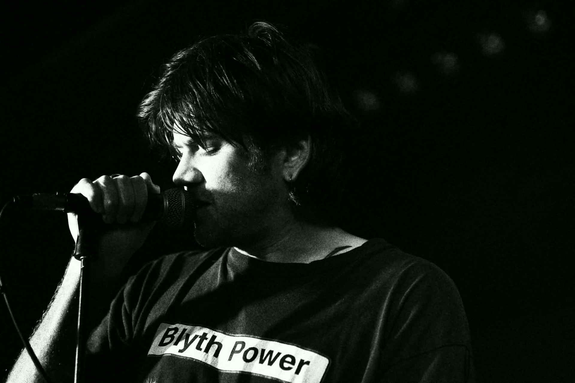 Black and white profile of a singer at the mic at The Water Rats, London